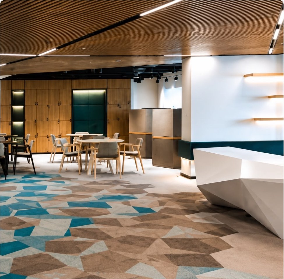 Reception area with slatted timber ceiling raft and back-lit shelving